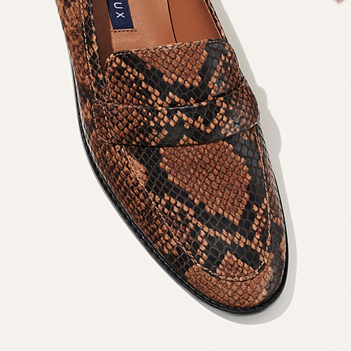 A top view of Margaux's The Andie Loafer in Espresso Python Embossed, showcasing its brown and black snakeskin pattern against a light background.
