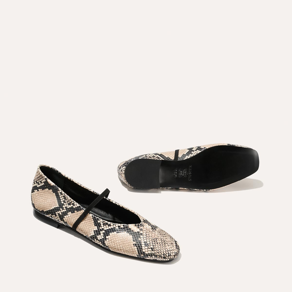 The Phoebe - Natural Python Embossed by margaux-development: Deconstructed flat Mary Jane shoes in black and beige python-embossed leather, with a black strap and soles, shown against a plain light background.