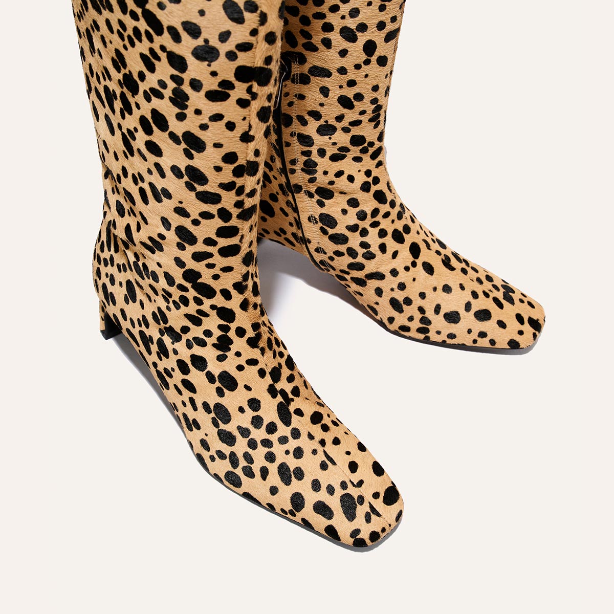 The Brera Knee-High Boot - Tan Cheetah Haircalf features a tan and black cheetah print, square toes, and a walkable, low heel.