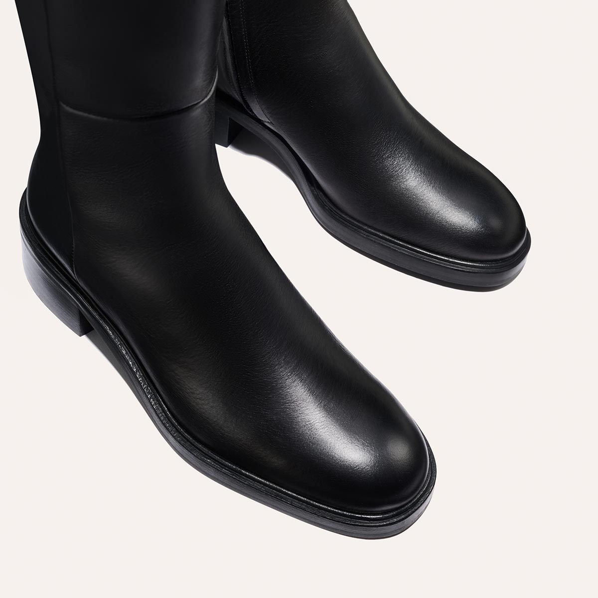The City Boot - Black Calf by Margaux features sleek black leather with a smooth finish, low heels, and a classic silhouette, shown from above on a light background.