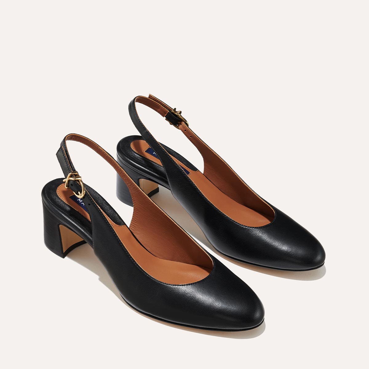 The Cluny Slingback in Black Nappa, featuring a sleek Italian nappa leather upper with an adjustable buckle and a comfortable 2.5-inch black heel.