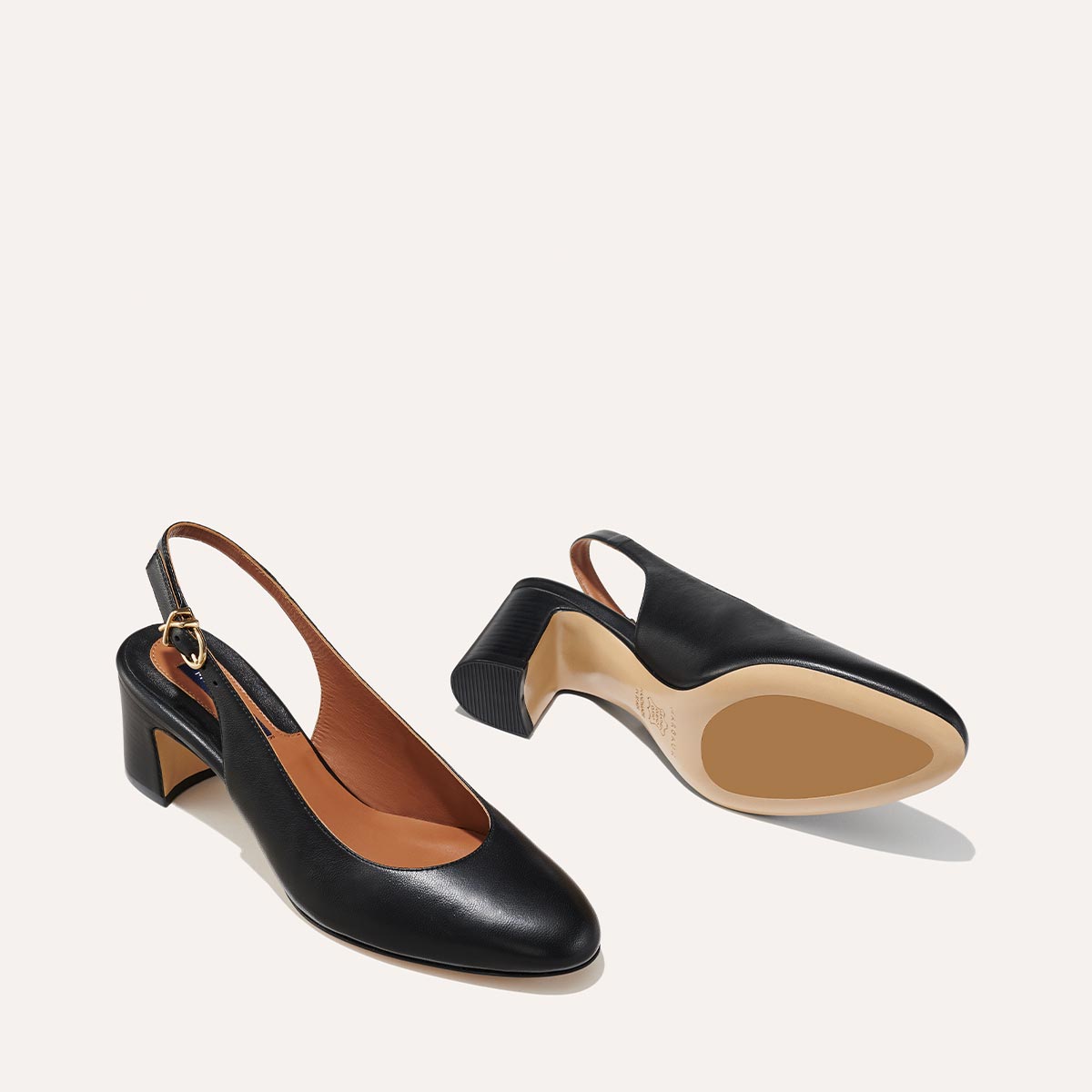 The Cluny Slingback in Black Nappa, featuring a sleek Italian nappa leather upper with an adjustable buckle and a comfortable 2.5-inch black heel.