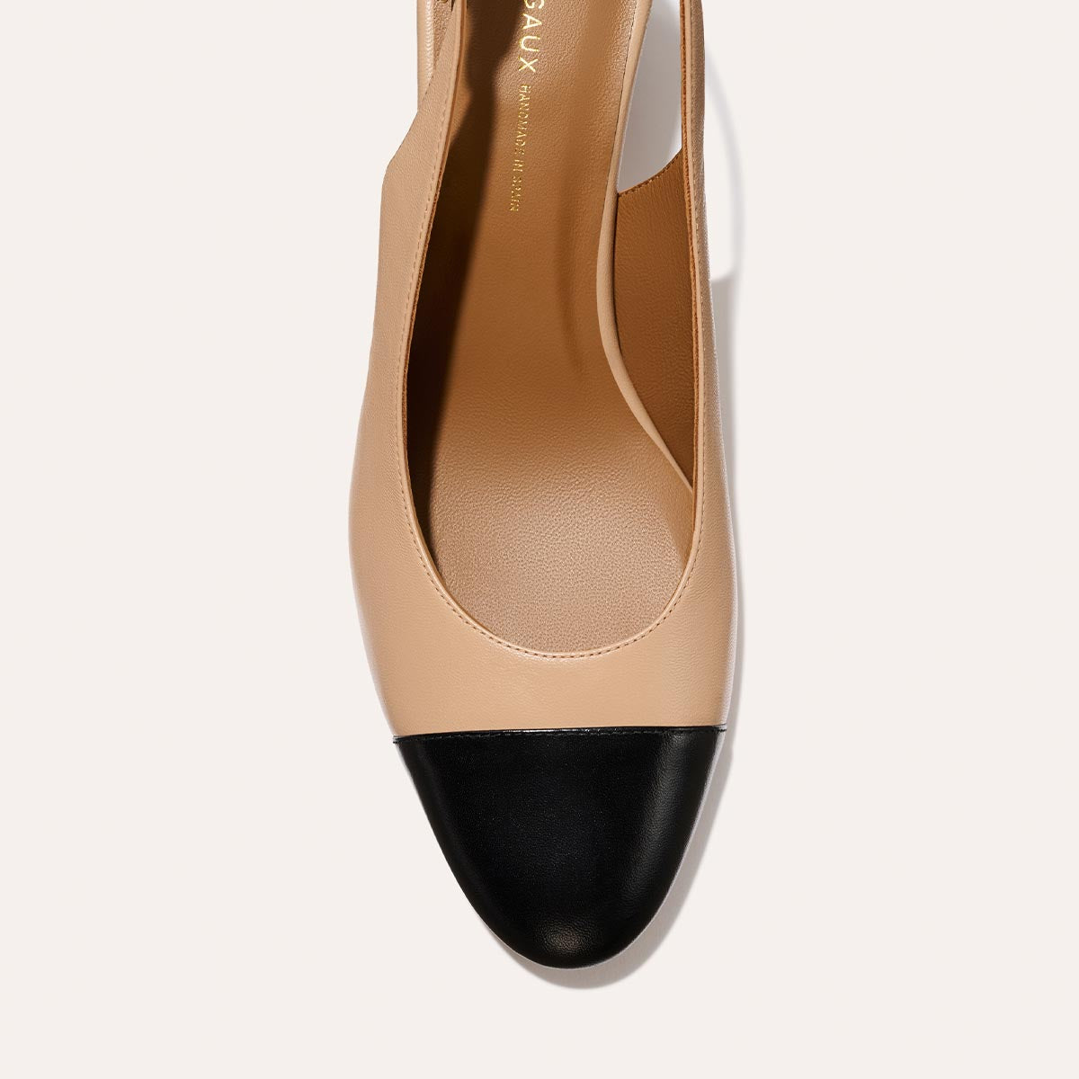 The Cluny Slingback in Dune Nappa, featuring a sleek captoe detail with an adjustable buckle and a comfortable 2.5-inch black heel.