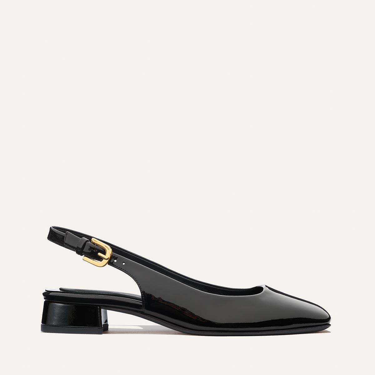 The Darcy Slingback by Margaux in black patent features an adjustable slingback, low block heel, and gold buckle—shown side profile against a light background—perfect for warm-weather style.