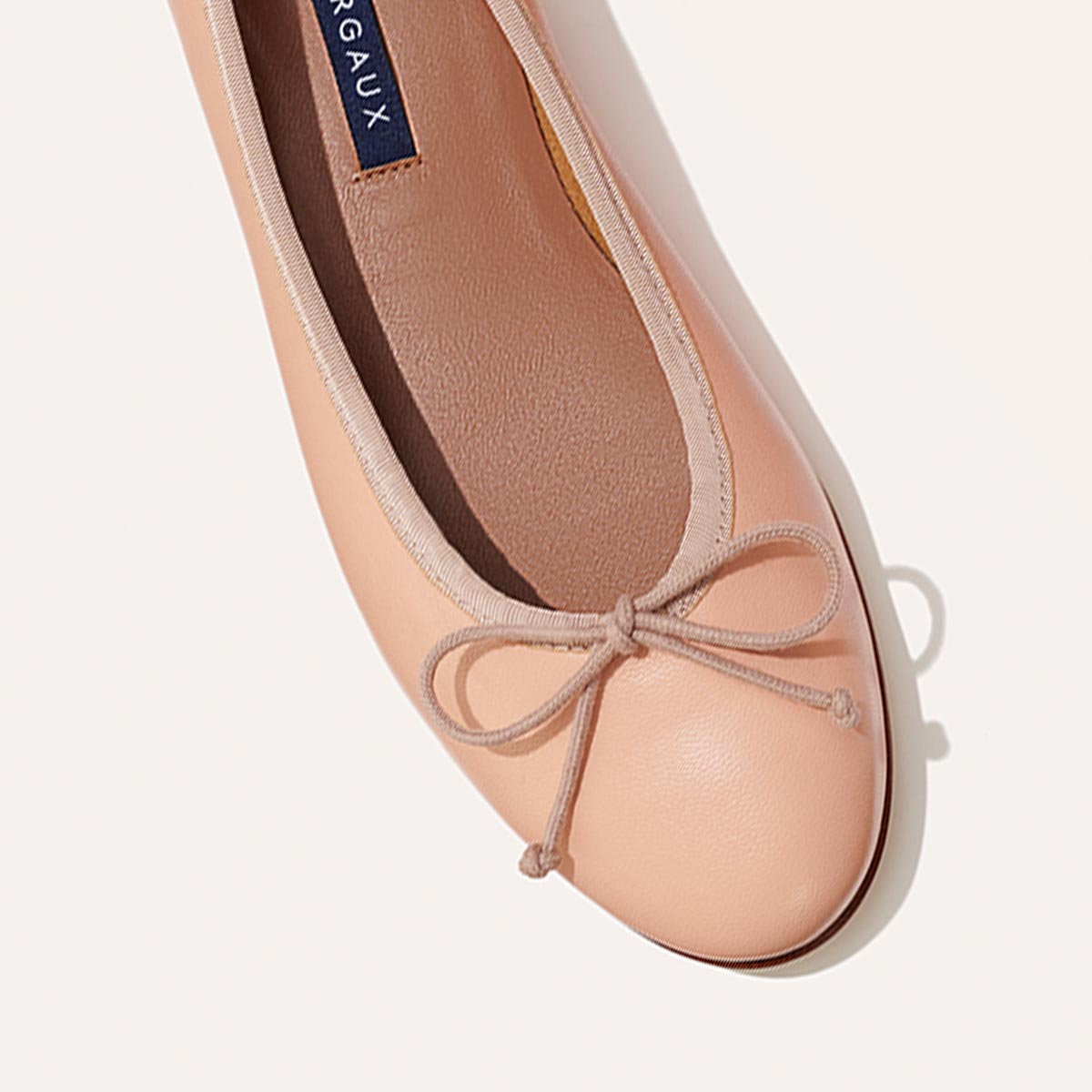 The Demi in Ballet Pink Nappa, a comfortable ballet flat with a rounded toe and adjustable cord bow detail.