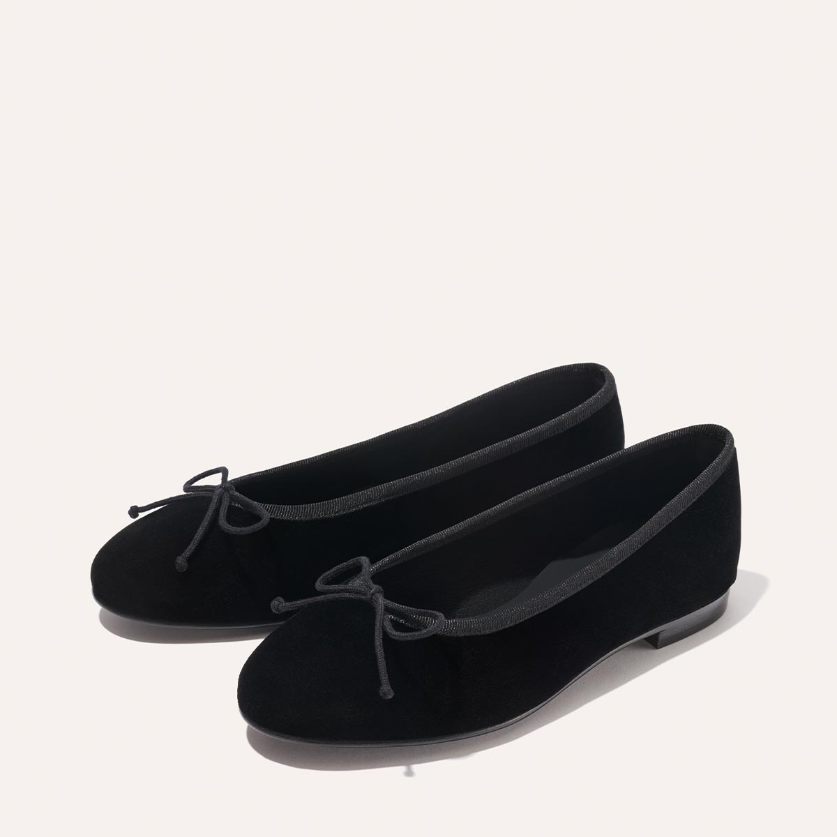The Demi - Black Velvet by margaux-development: black ballet flats with rounded toes and small bows on the front, shown against a light background.