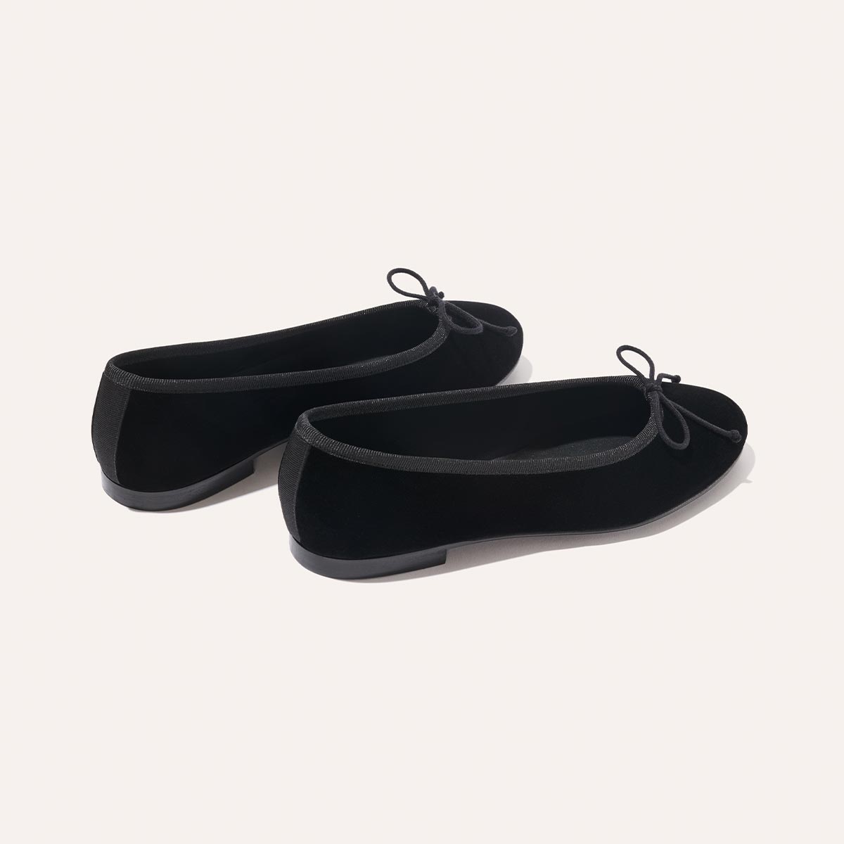 The Demi - Black Velvet by margaux-development: black velvet ballet flats featuring small bows on the toes, shown against a plain light background.