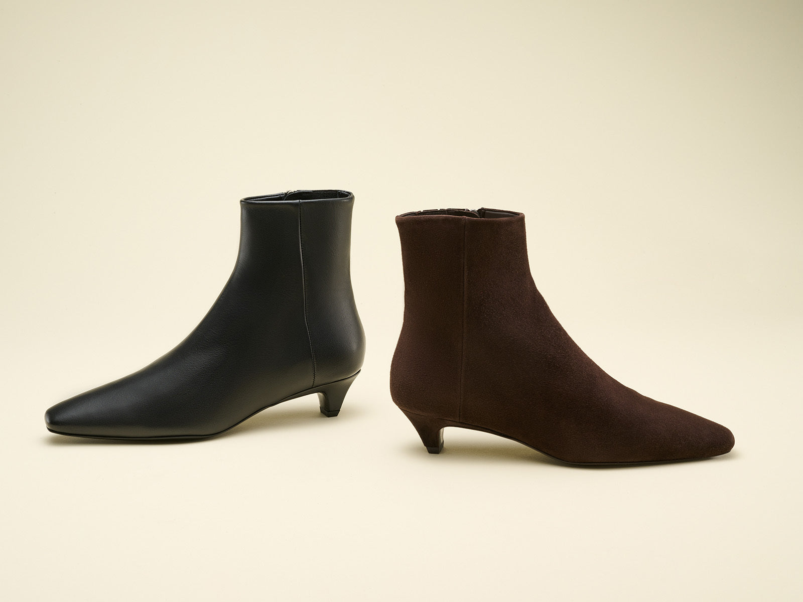 Black and brown ankle boots on a beige background