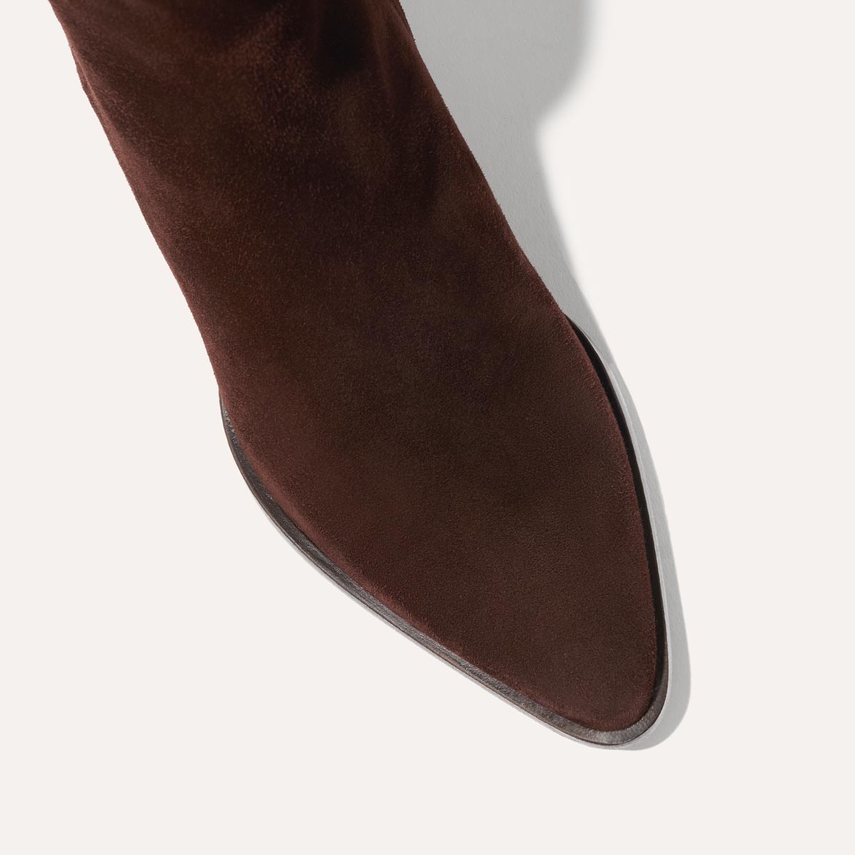 The Downtown Boot in Chocolate Suede, a chic ankle-height design complete with a Western-inspired welt and a comfortable 2.5-inch stacked heel.