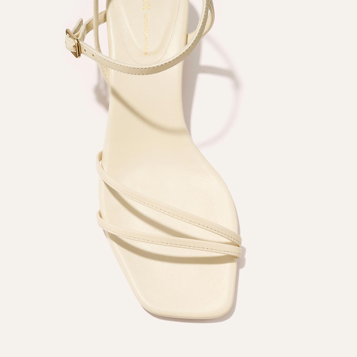 Cream colored high-heeled sandal on a white background
