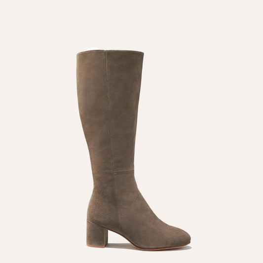 Margaux's knee-grazing Edie Boot in soft, taupe Italian suede with walkable heel and almond-shaped toe
