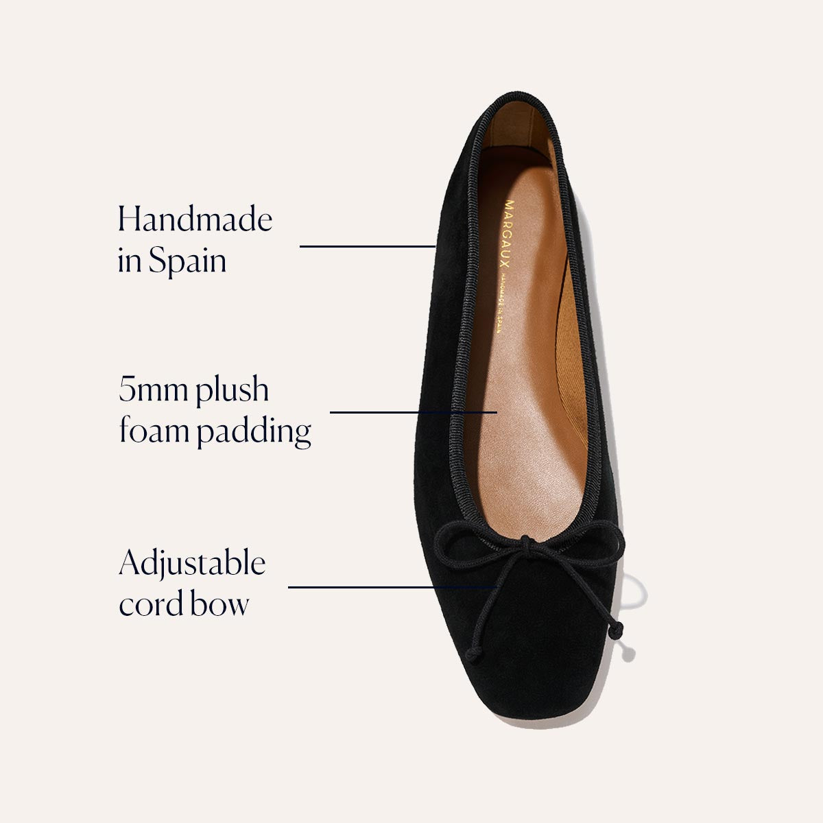 The Fonteyn - Black Suede by Margaux is a black ballet flat, handcrafted in Spain with 5mm plush foam padding and an adjustable cord bow. Labels highlight its comfort-focused design as viewed from above on a light background.