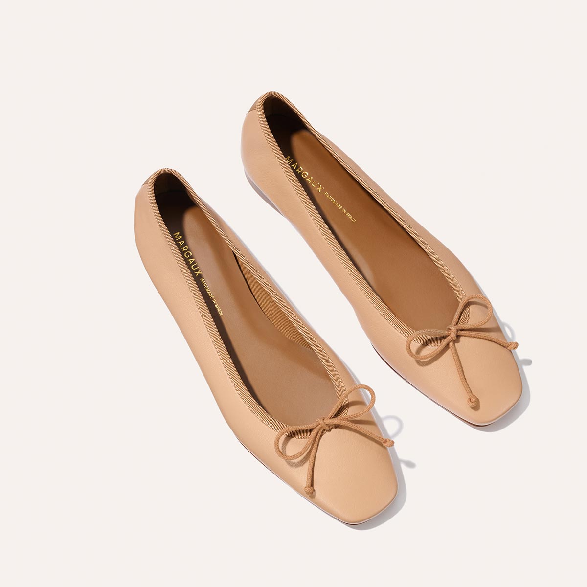 The Fonteyn - Dune Nappa ballet flats by Margaux feature a beige hue, square toe, and bow detail, shown side by side on a light background.