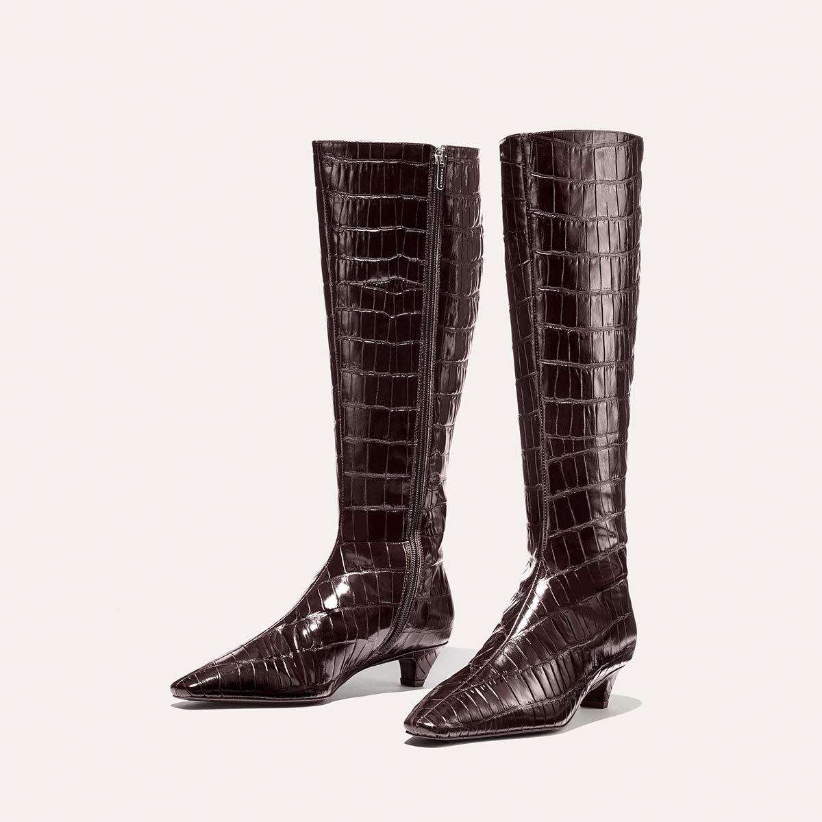 The Imogen - Espresso Croc Embossed by Margaux are knee-high, dark brown, crocodile-embossed leather boots with pointed toes and low heels, shown against a plain light background.