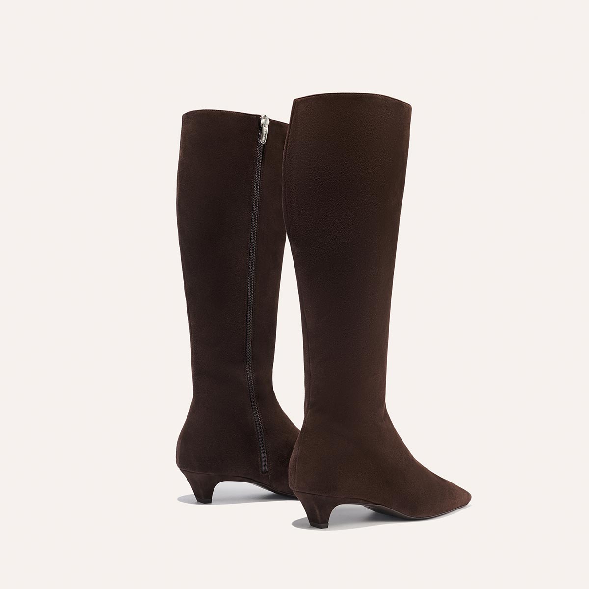 The Imogen - Espresso Suede by Margaux: dark brown knee-high suede boots with pointed toes, low kitten heels, and side zippers, shown against a plain light background.