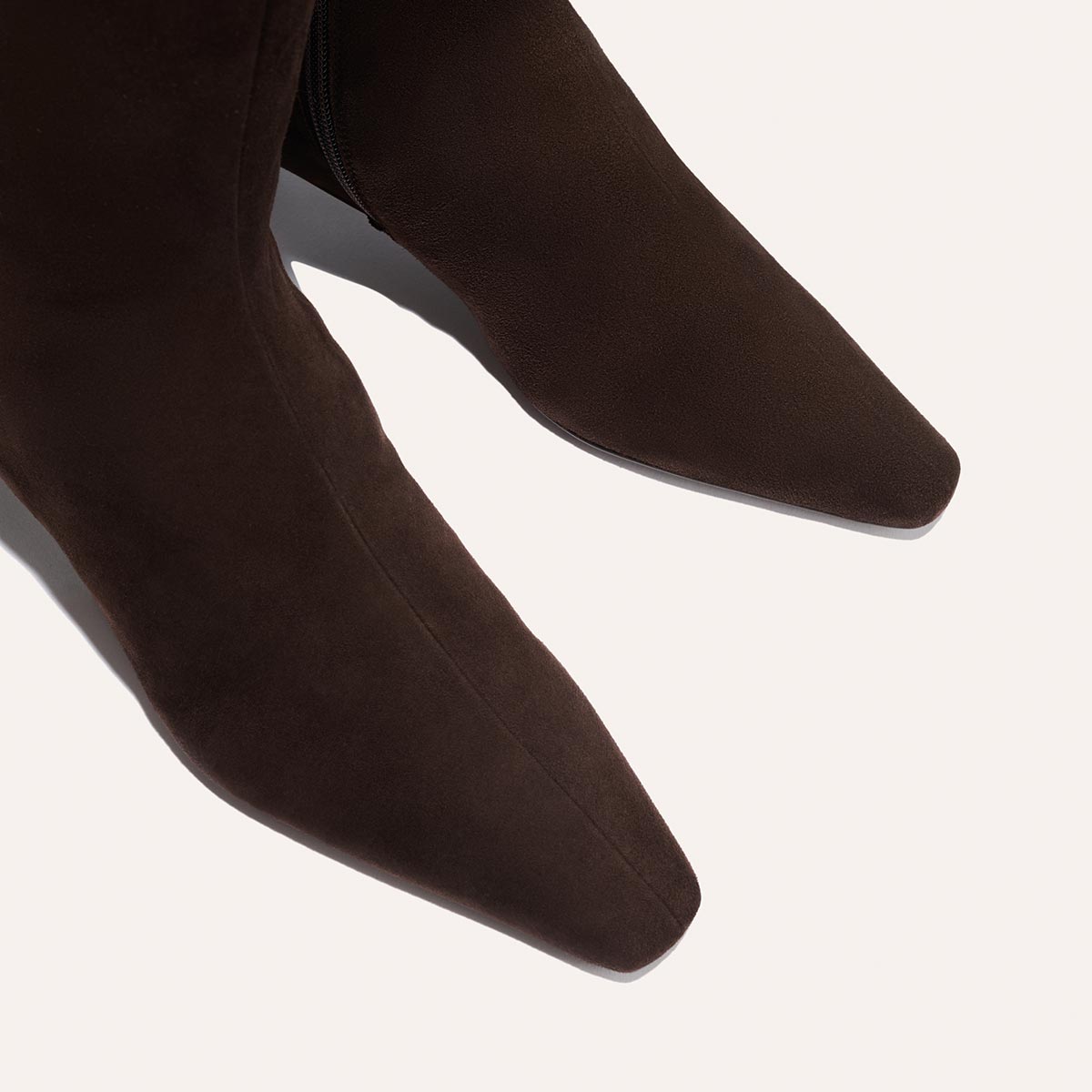 Close-up of The Imogen - Espresso Suede boots by Margaux, featuring a dark brown pointed-toe suede design against a light background.