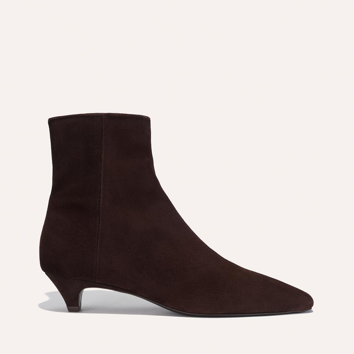 The Alex Mill x Margaux: The Inga - Espresso Suede by margaux-development is a dark brown suede ankle boot featuring a pointed toe and low kitten heel, offering an elevated New York City-inspired style against a clean background.