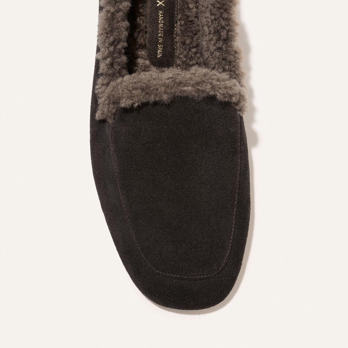 The James Loafer in dark chocolate suede, featuring a sacchetto construction and a dark gray shearling lining.