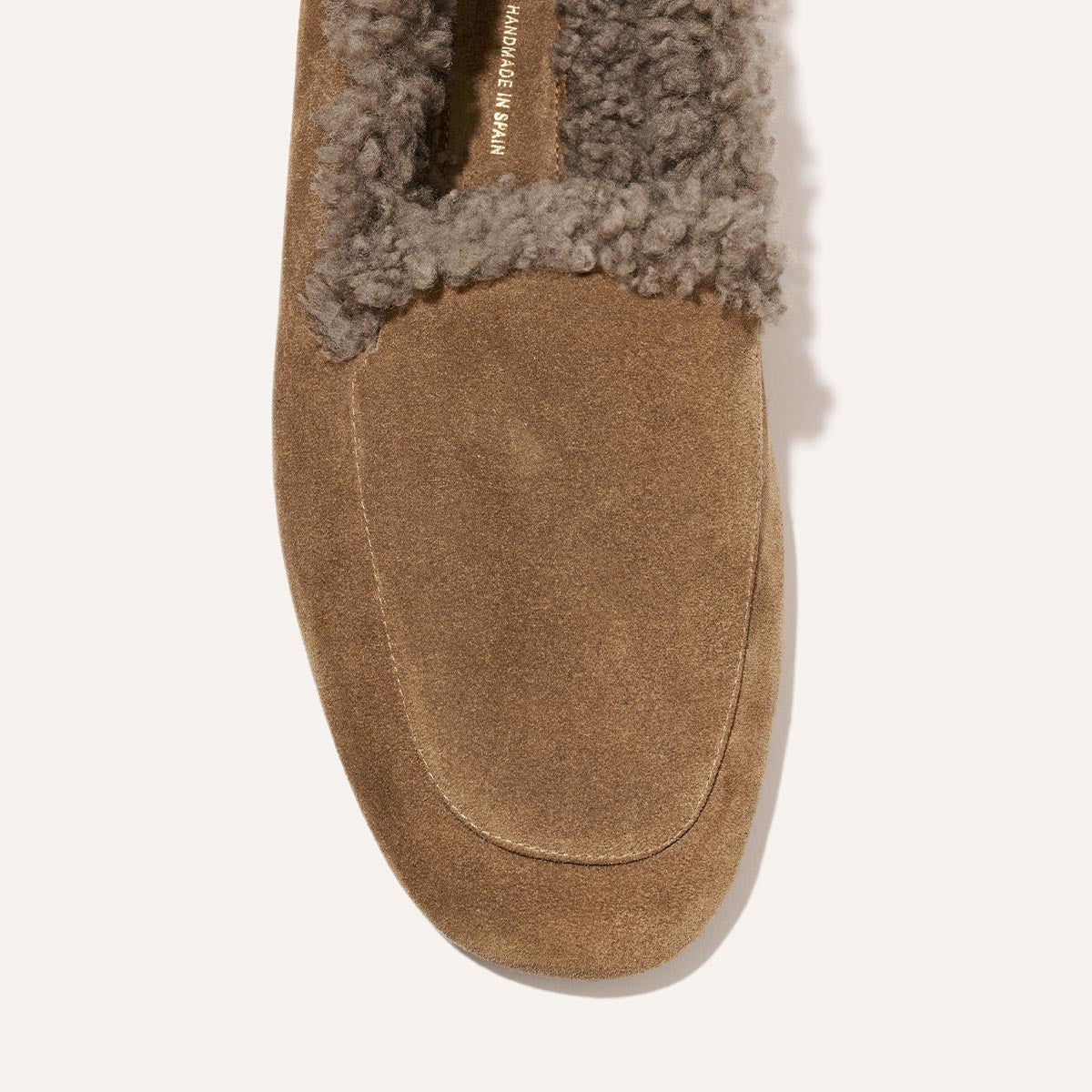 The James Loafer in driftwood suede and shearling features a grey shearling lining, a sacchetto construction, and Handmade in Spain printed on the inner sole.