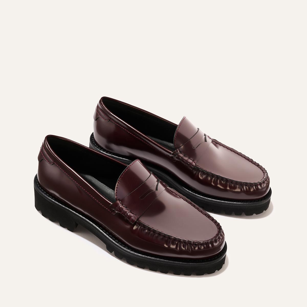 The Louisa Loafer by Margaux in burgundy calf leather features moccasin-style stitching, a polished finish, black rubber soles, and leather lining for a comfortable, timeless look—beautifully displayed on a light background.
