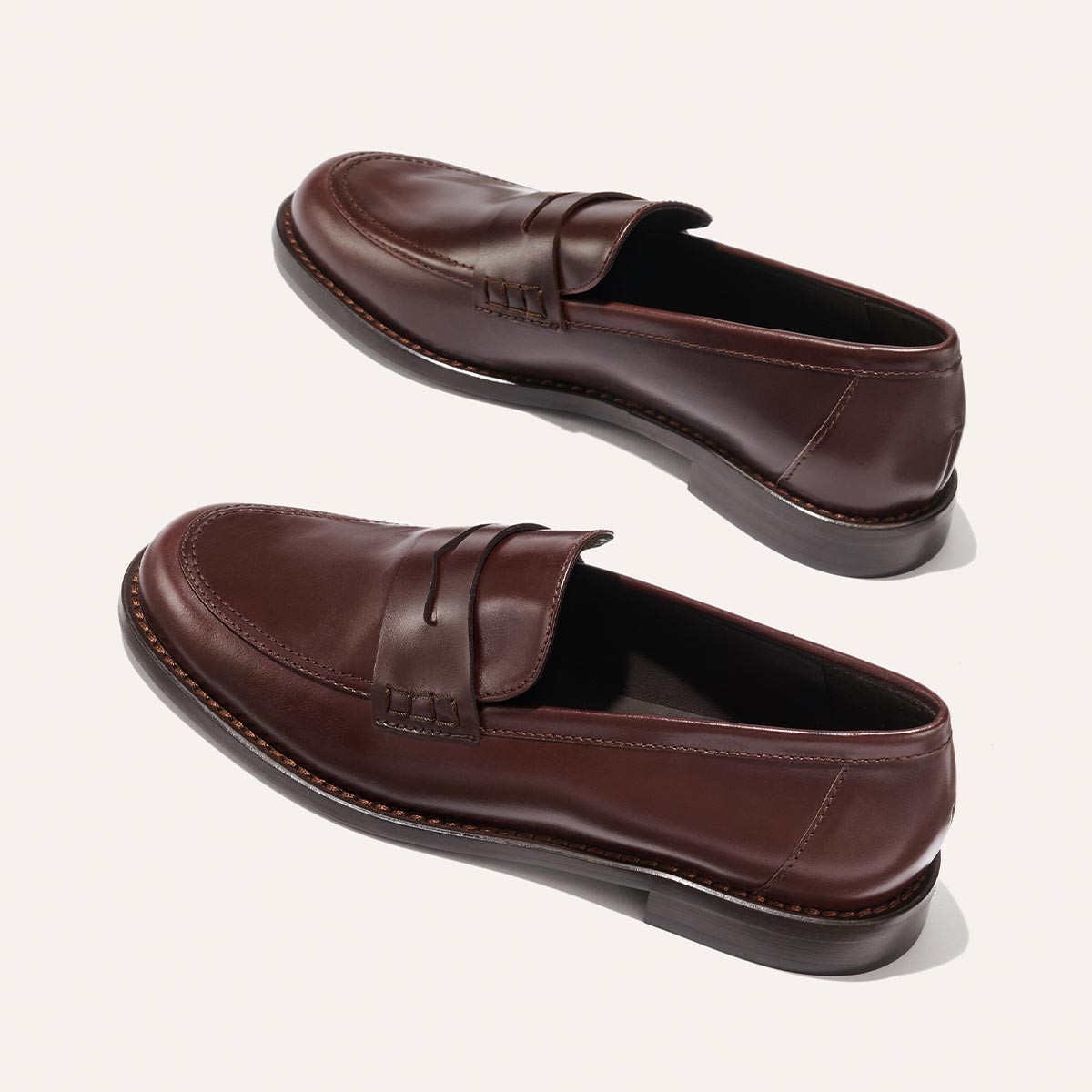 The Marlowe Loafer - Mahogany Calf by Margaux features classic brown leather with stitched accents and dark soles, elegantly displayed on a light background.