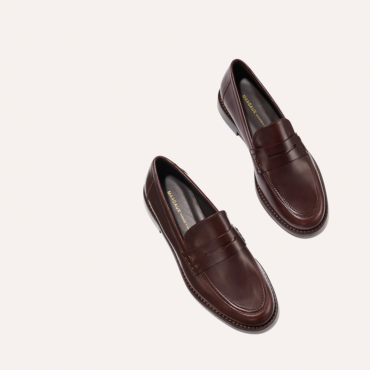 The Marlowe Loafer - Mahogany Calf by Margaux features brown leather, stitching detail, and slightly pointed toes, shown against a plain light background.