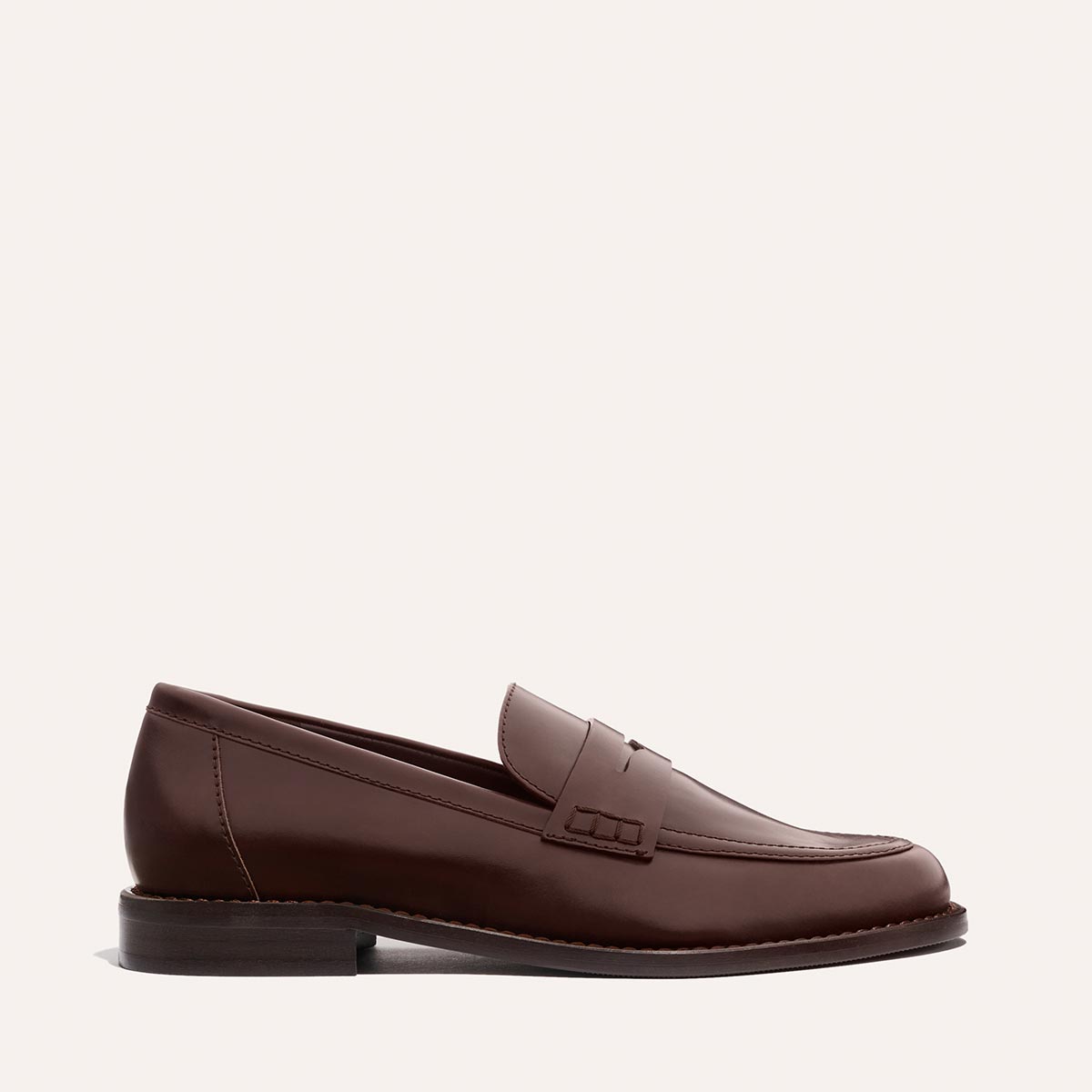 The Marlowe Loafer - Mahogany Calf by Margaux is shown in profile, featuring brown leather, stitched detailing, and a low heel against a plain light background.