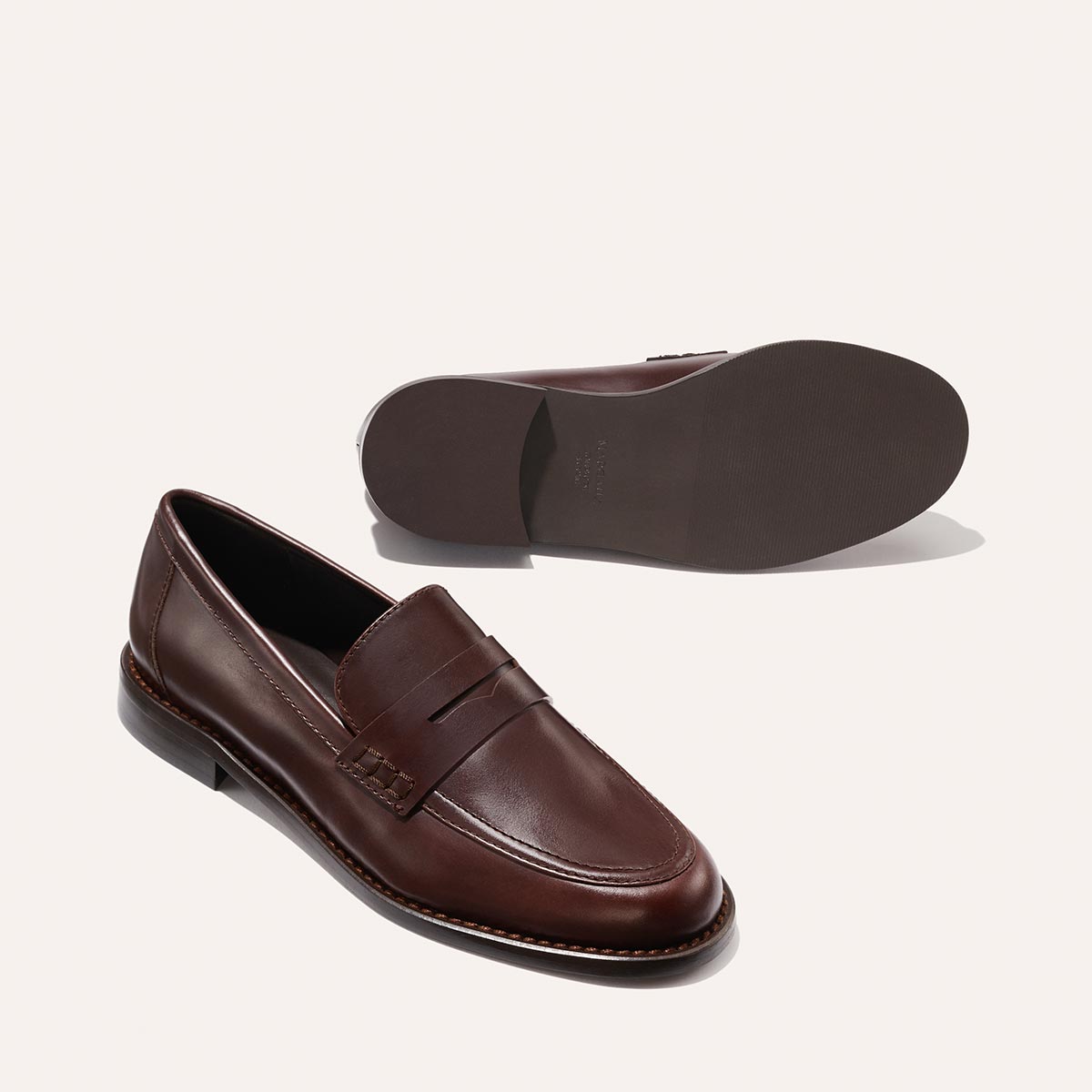 The Marlowe Loafer - Mahogany Calf by Margaux, shown with one shoe upright to highlight the top and side, and the other on its side displaying the sole.
