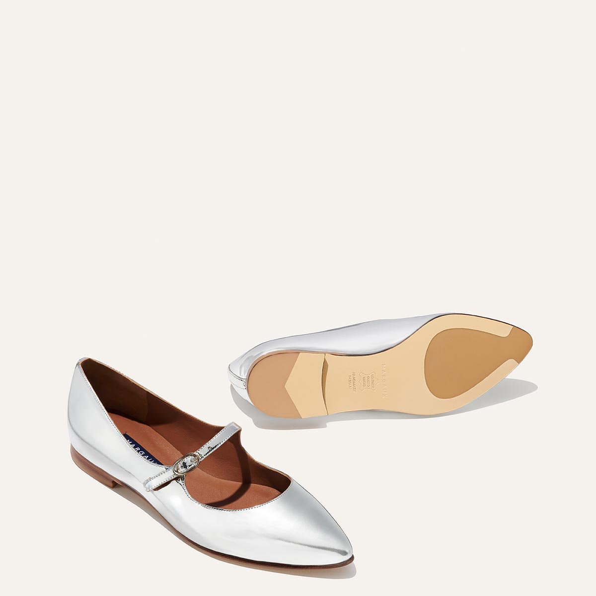 The Mary Jane in shiny Silver Mirror Patent, a ballet flat with a pointed toe and an adjustable strap for a secure fit.