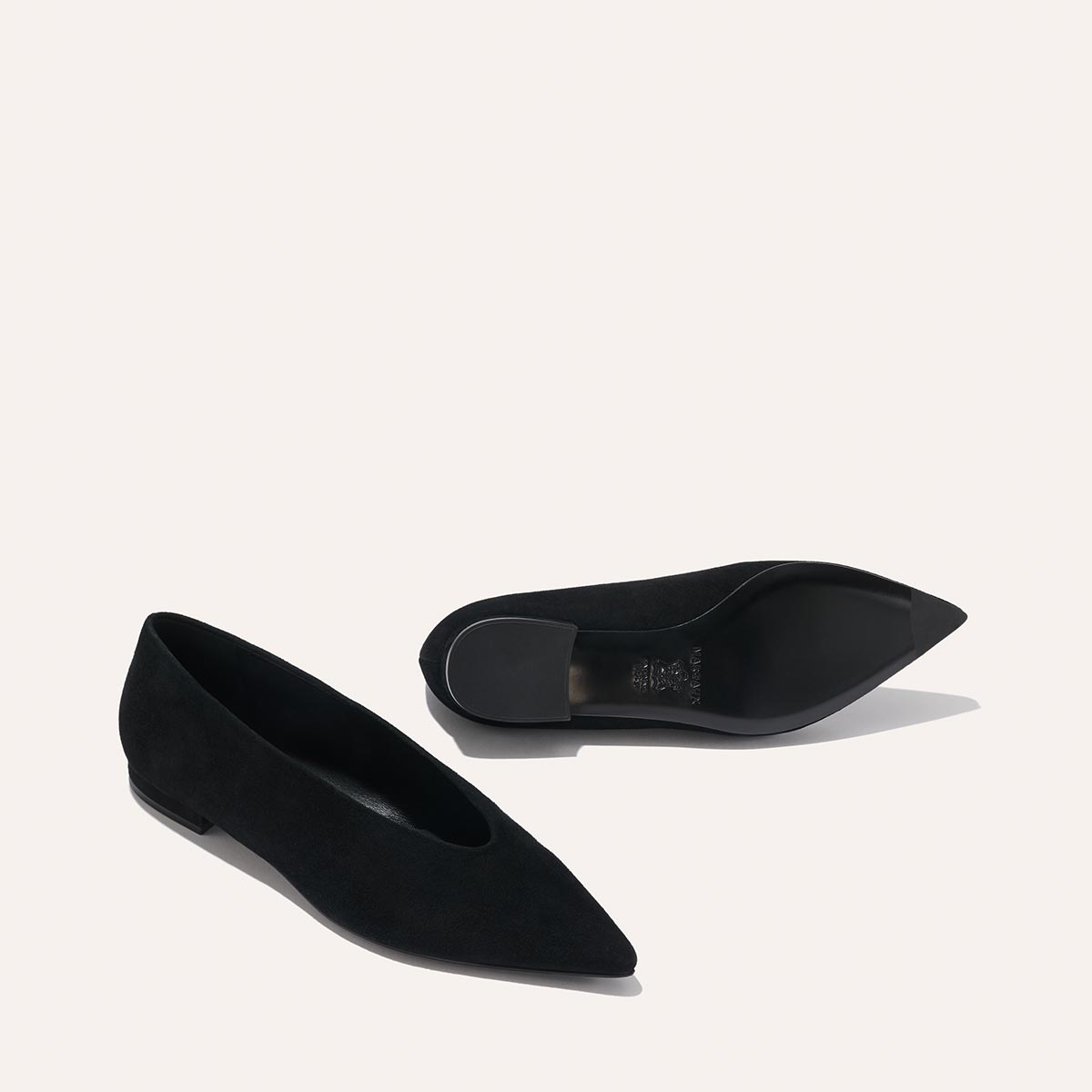 The Parra - Black Suede flats by margaux-development: black pointed-toe shoes with a structured silhouette, one upright and one on its side showing the sole, set against a plain light background.