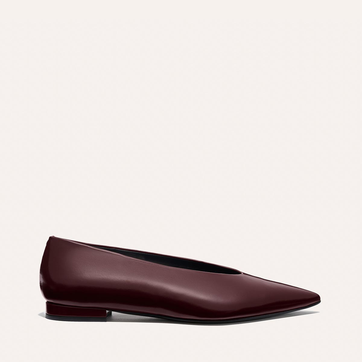 The Parra - Burgundy Calf by margaux-development is a burgundy pointed-toe flat with a high vamp and low heel, crafted from shiny leather in a structured silhouette, shown on a neutral light background.