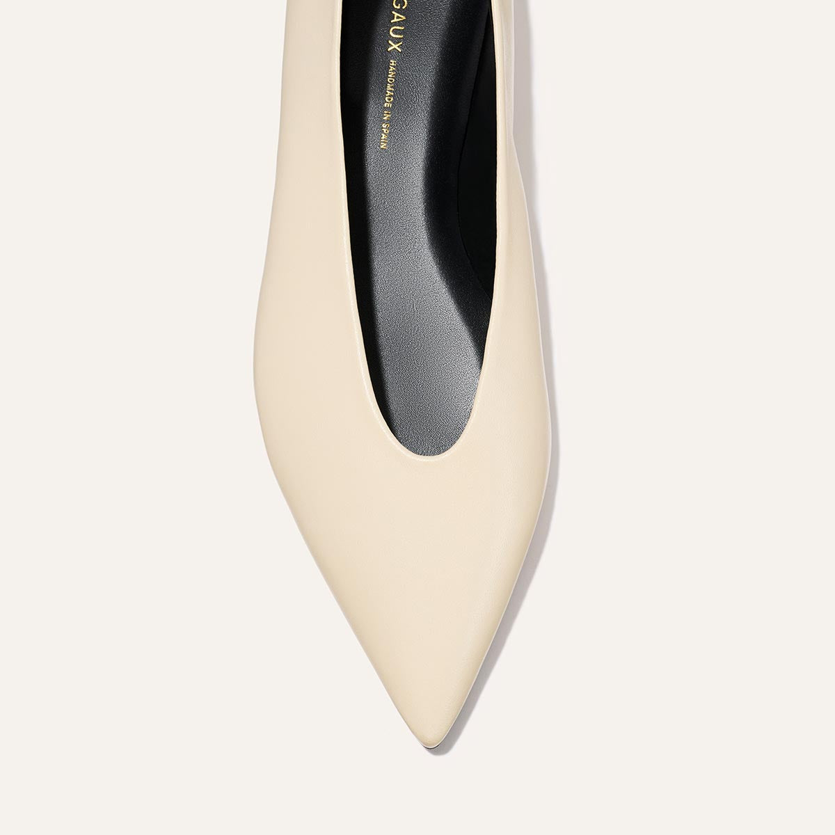 Top view of The Parra - Ivoire Nappa by margaux-development: a single beige pointed-toe shoe with a black insole, displayed against a light background.