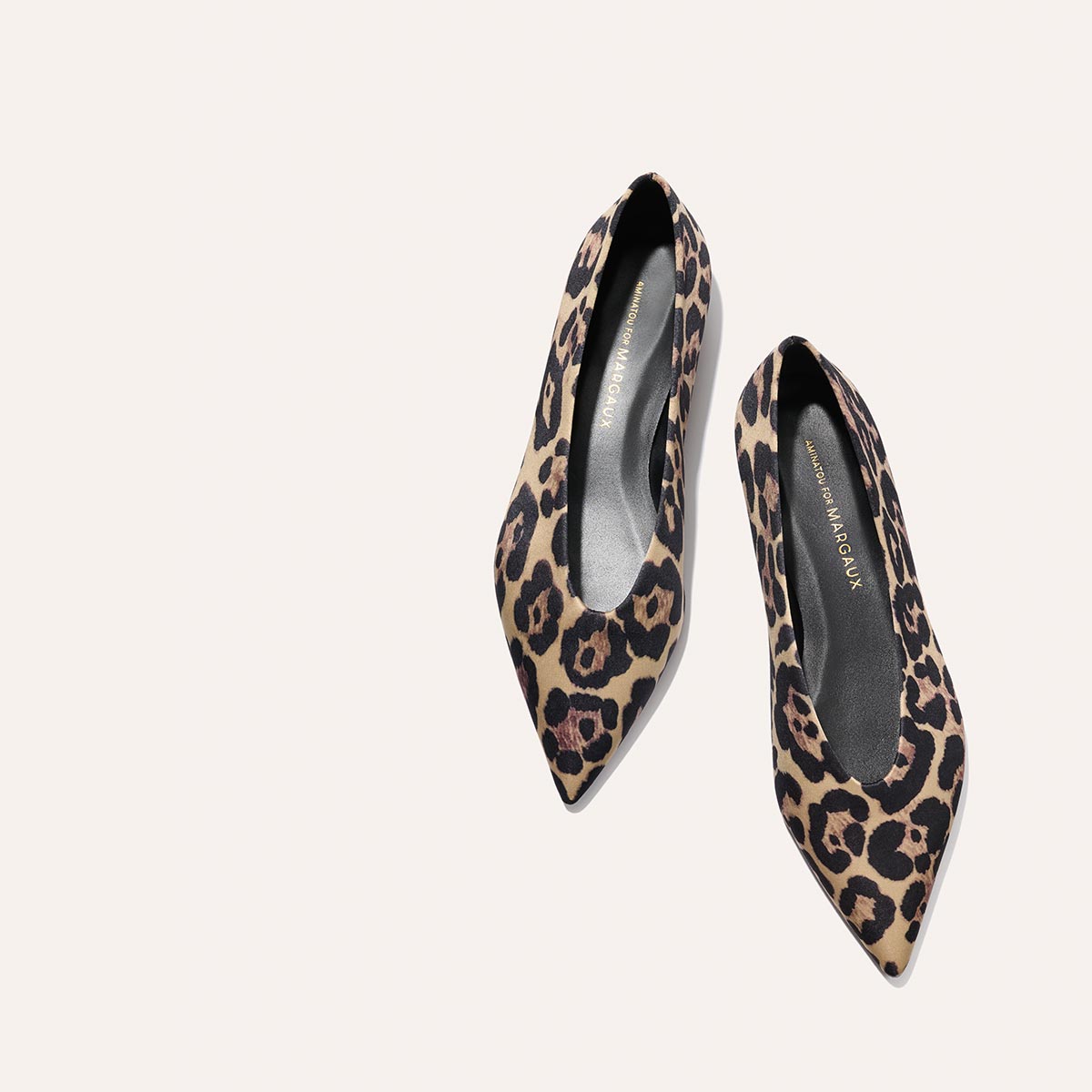 The Parra - Leopard Satin flats by margaux-development, featuring a pointed-toe and leopard print, displayed on a light beige background.