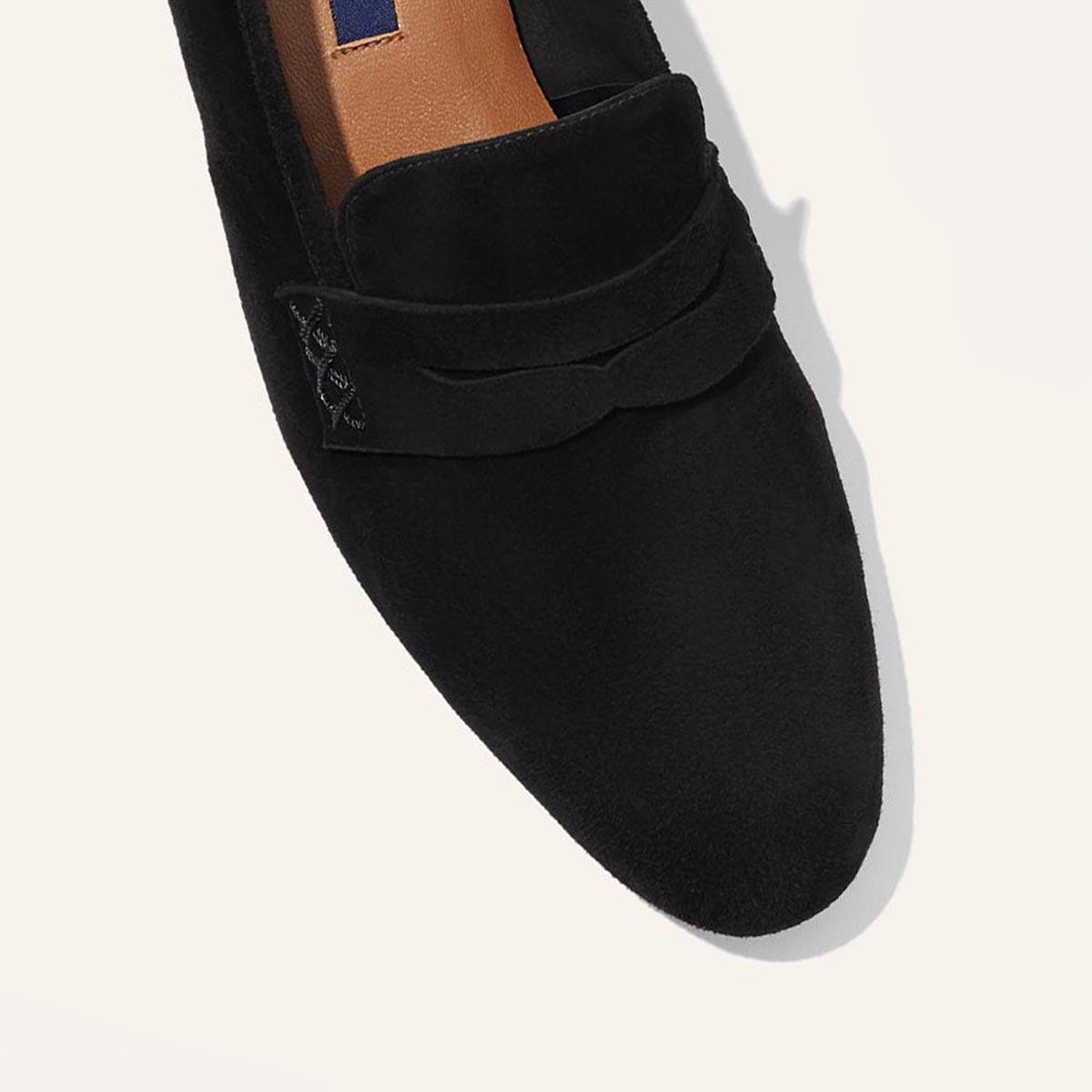 The Penny Loafer in Black Suede, featuring an ultra-luxe Italian suede upper with an unlined construction for a glove-like fit.