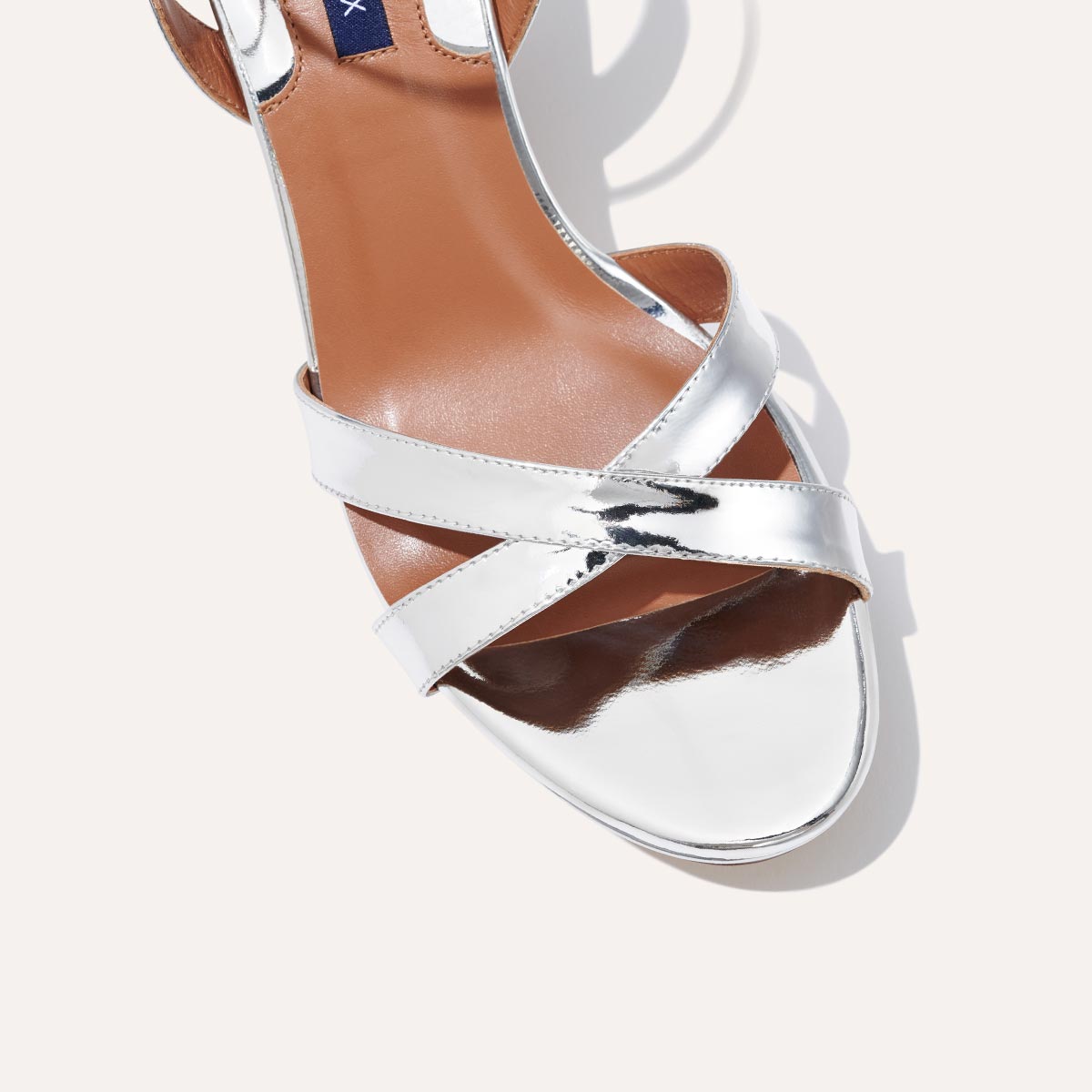 The Platform Sandal in shiny Silver Mirror, featuring a sleek ankle strap, perfectly placed straps across the toes and a comfortable 3.5-inch block heel.