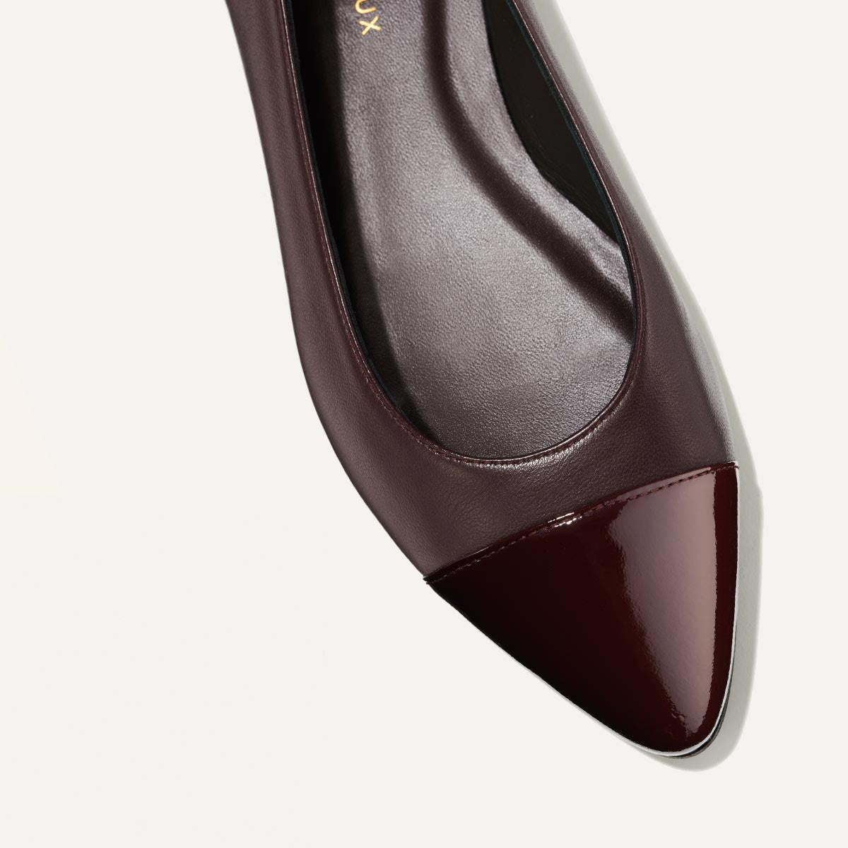 The Pointe in burgundy nappa, a classic and comfortable ballet flat featuring a refined pointed toe design and patent cap-toe detail.