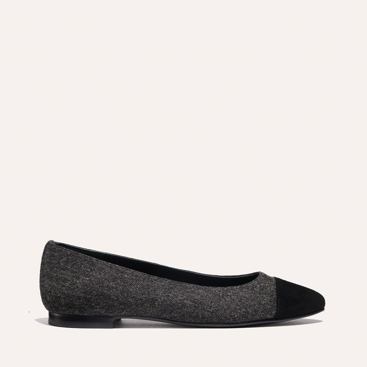 The Pointe - Grey Flannel by margaux-development is a gray ballet flat with a black toe cap and low black heel, shown against a simple light background.