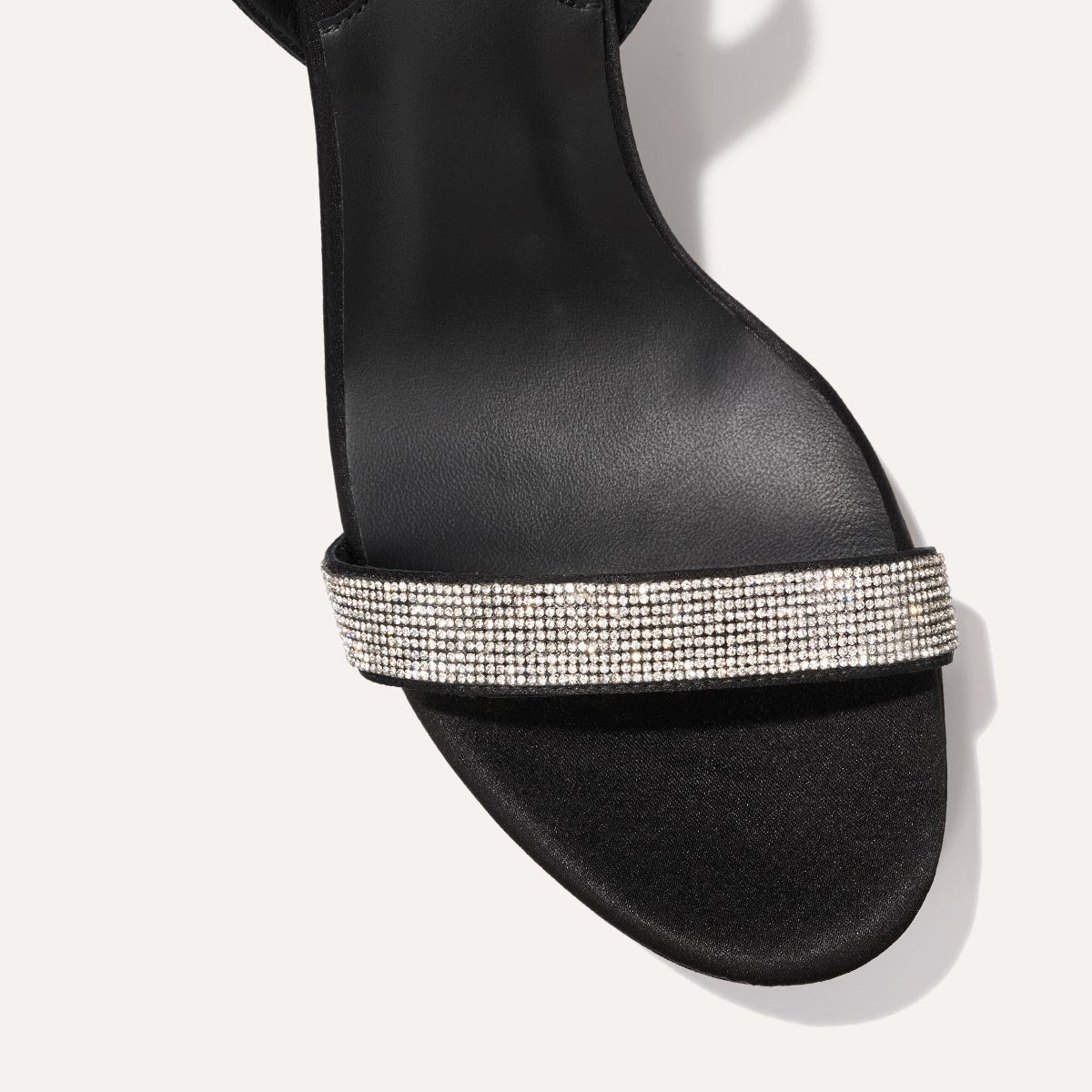 The Stella Platform in Black Satin with Crystals, featuring a sleek strap across the toes and a comfortable 3.5-inch block heel and platform.