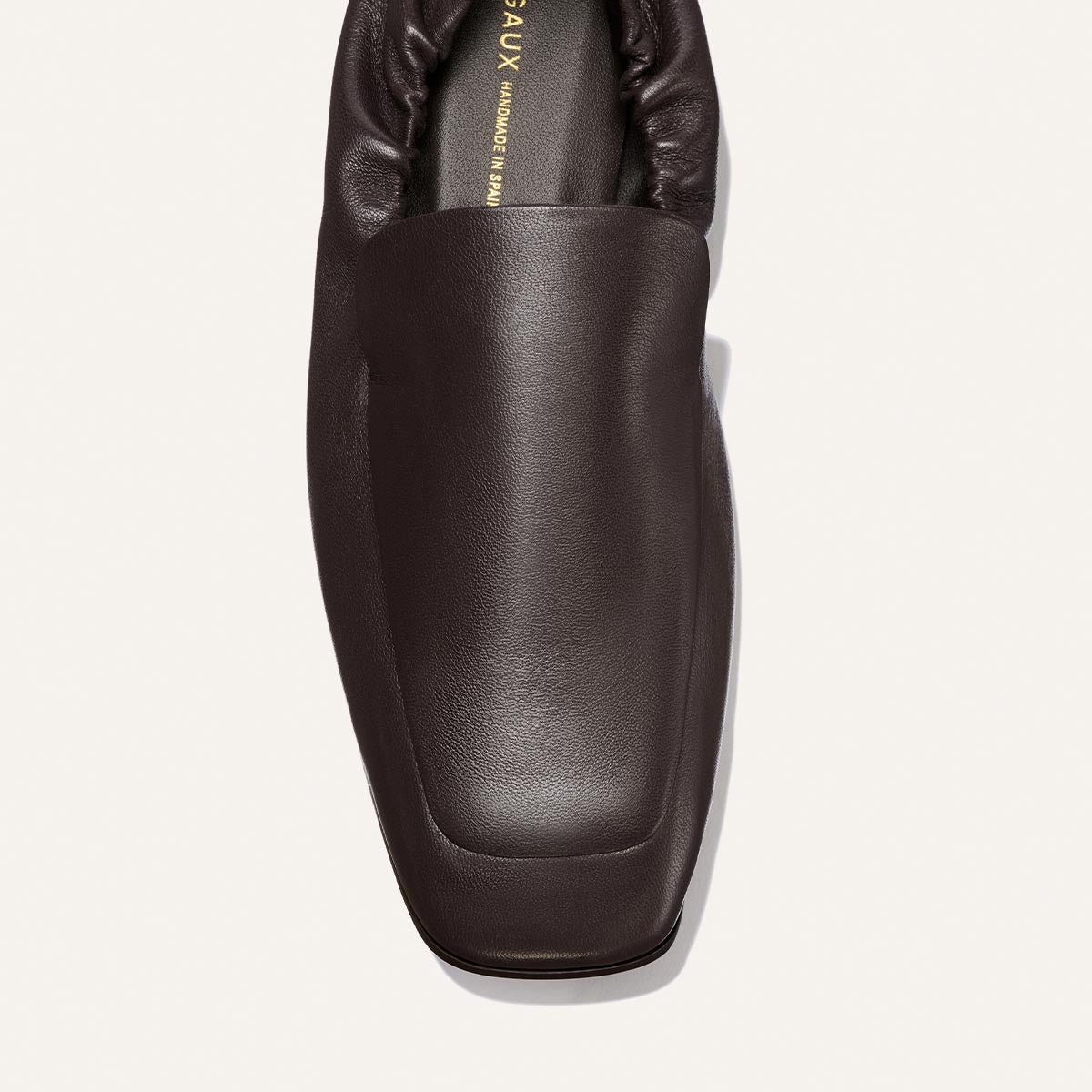 A close-up top view of Margaux's The Studio Loafer in Espresso Nappa showcases its dark brown leather finish, square toe design, and soft, cushioned collar against a plain light background.