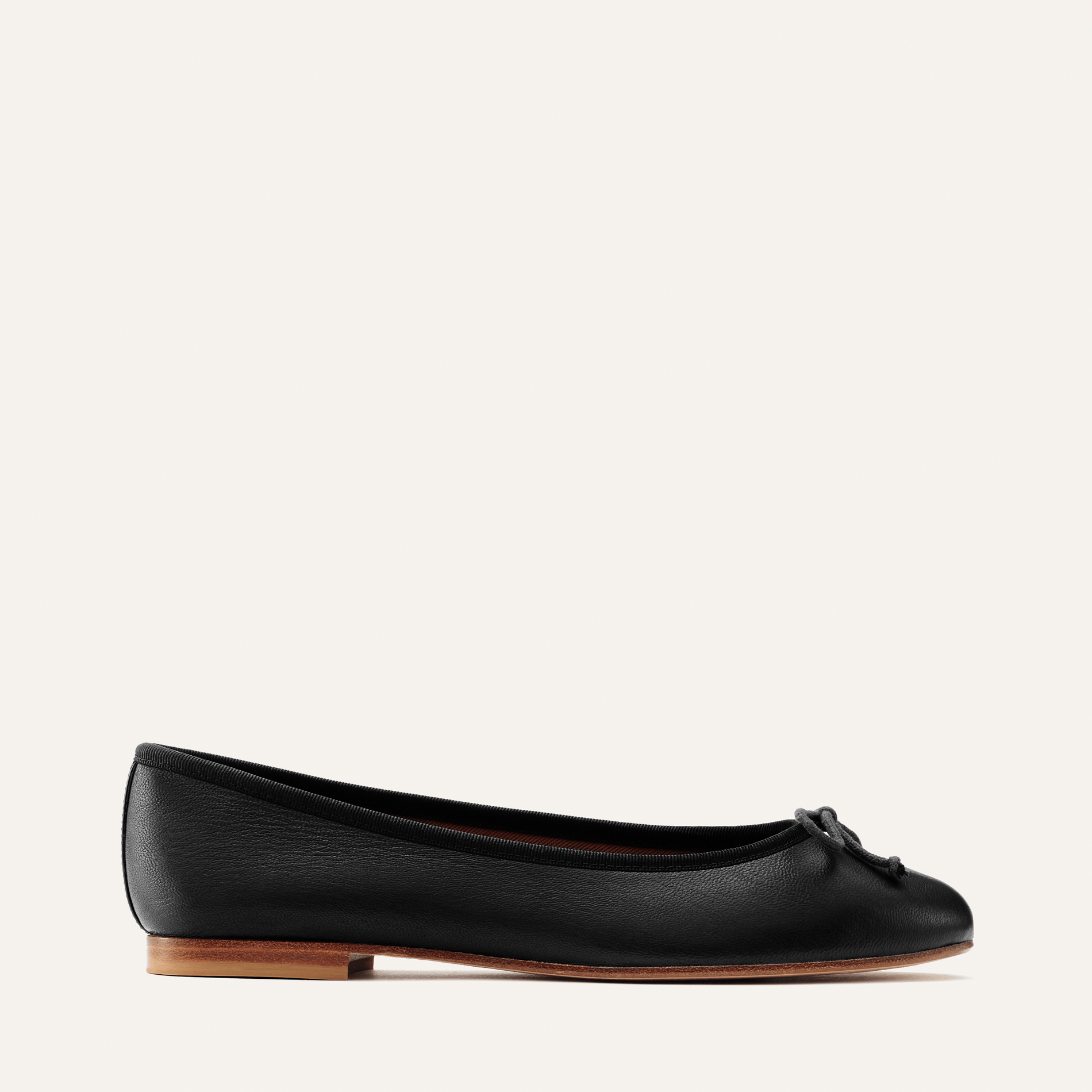 The Demi in Black Nappa, a comfortable ballet flat with a rounded toe and adjustable cord bow detail.