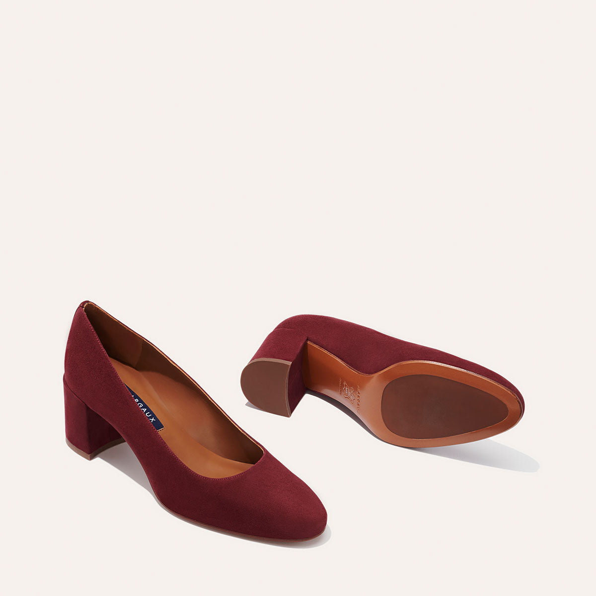 The Heel in Burgundy Suede, a classic block heel featuring a sleek almond toe design complemented by a comfortable 2.5-inch heel.