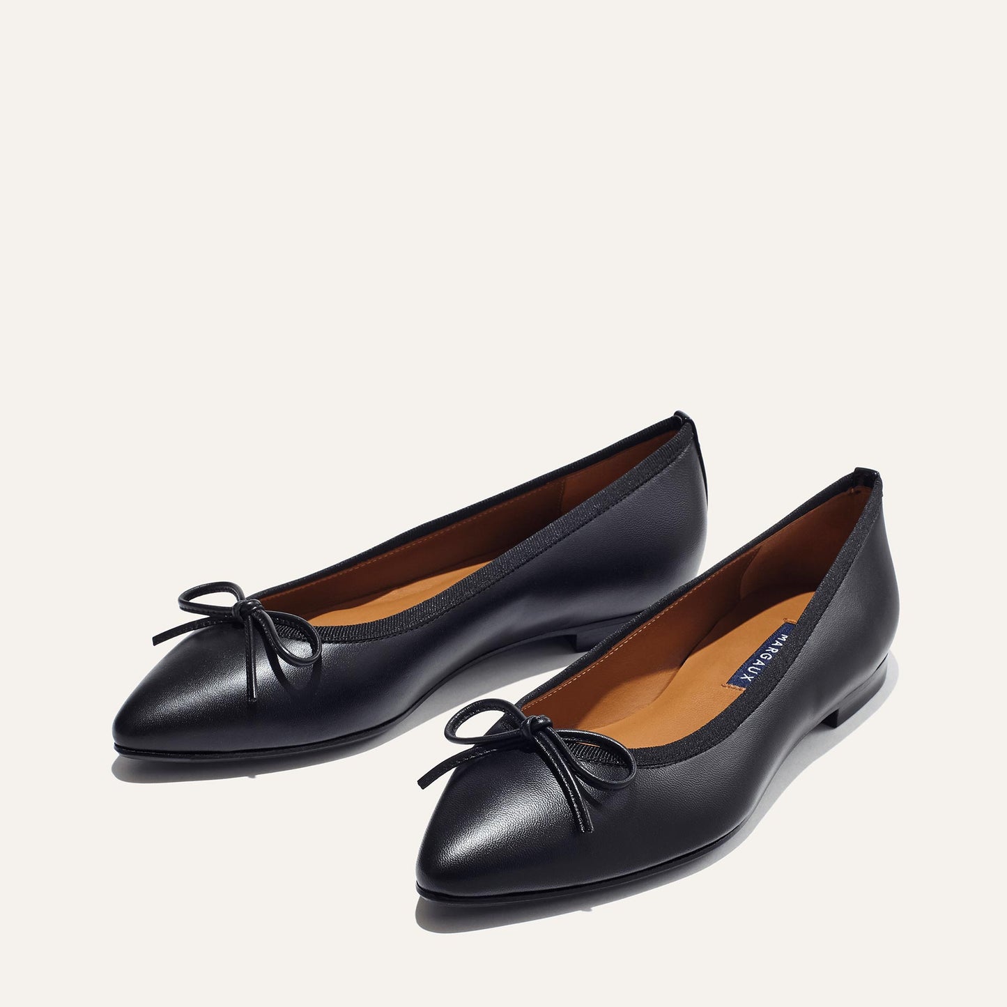 The Pointe in Black Nappa, a classic and comfortable ballet flat featuring a refined pointed toe design and decorative bow.