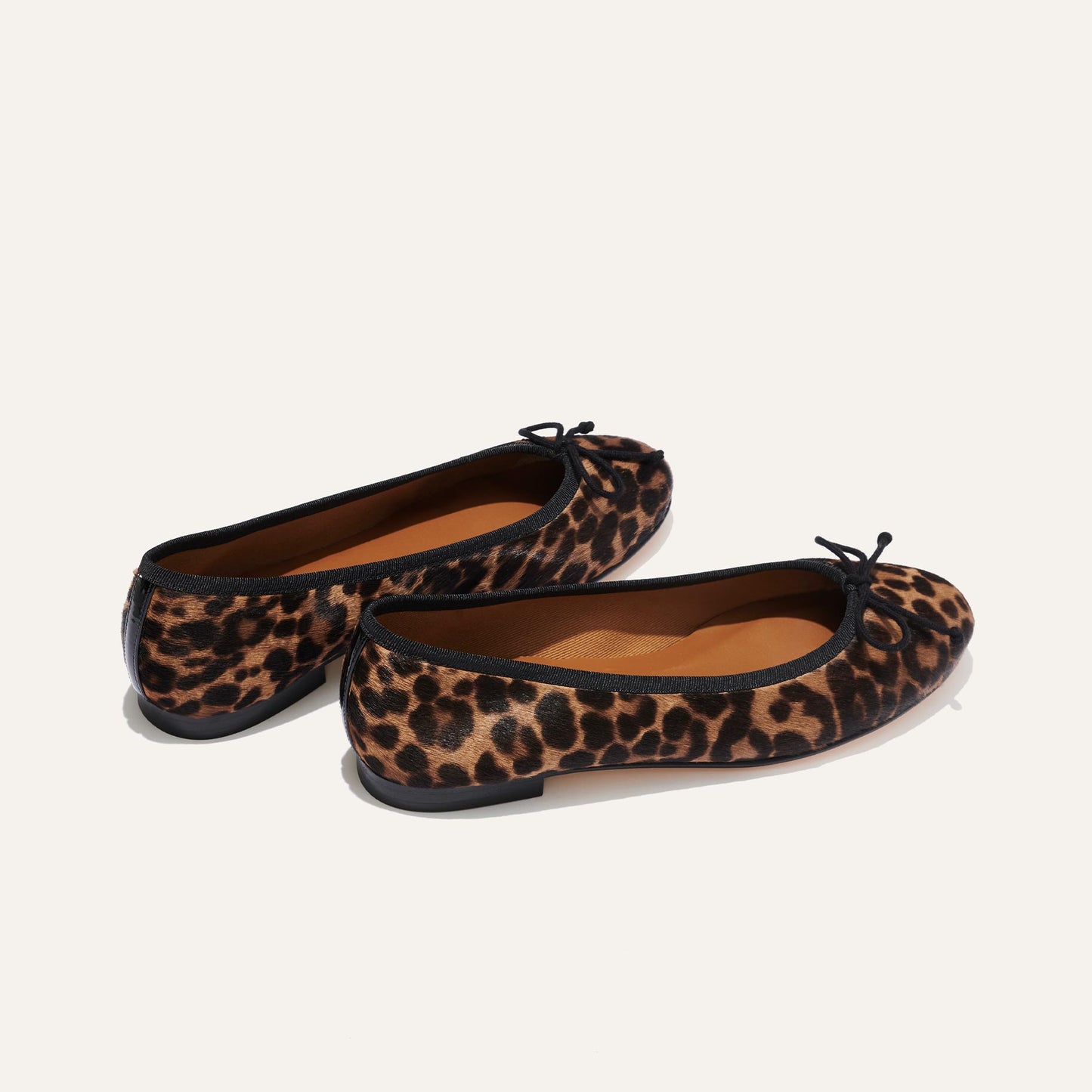 The Demi - Chocolate Leopard Haircalf by margaux-development: women’s handmade Spanish ballet flats with a leopard print, black trim, and small black bows, shown on a plain light background.
