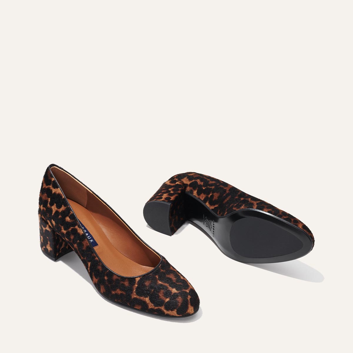 The Heel in Chocolate Leopard Haircalf, a classic block heel featuring a sleek almond toe design complemented by a comfortable 2.5-inch heel.