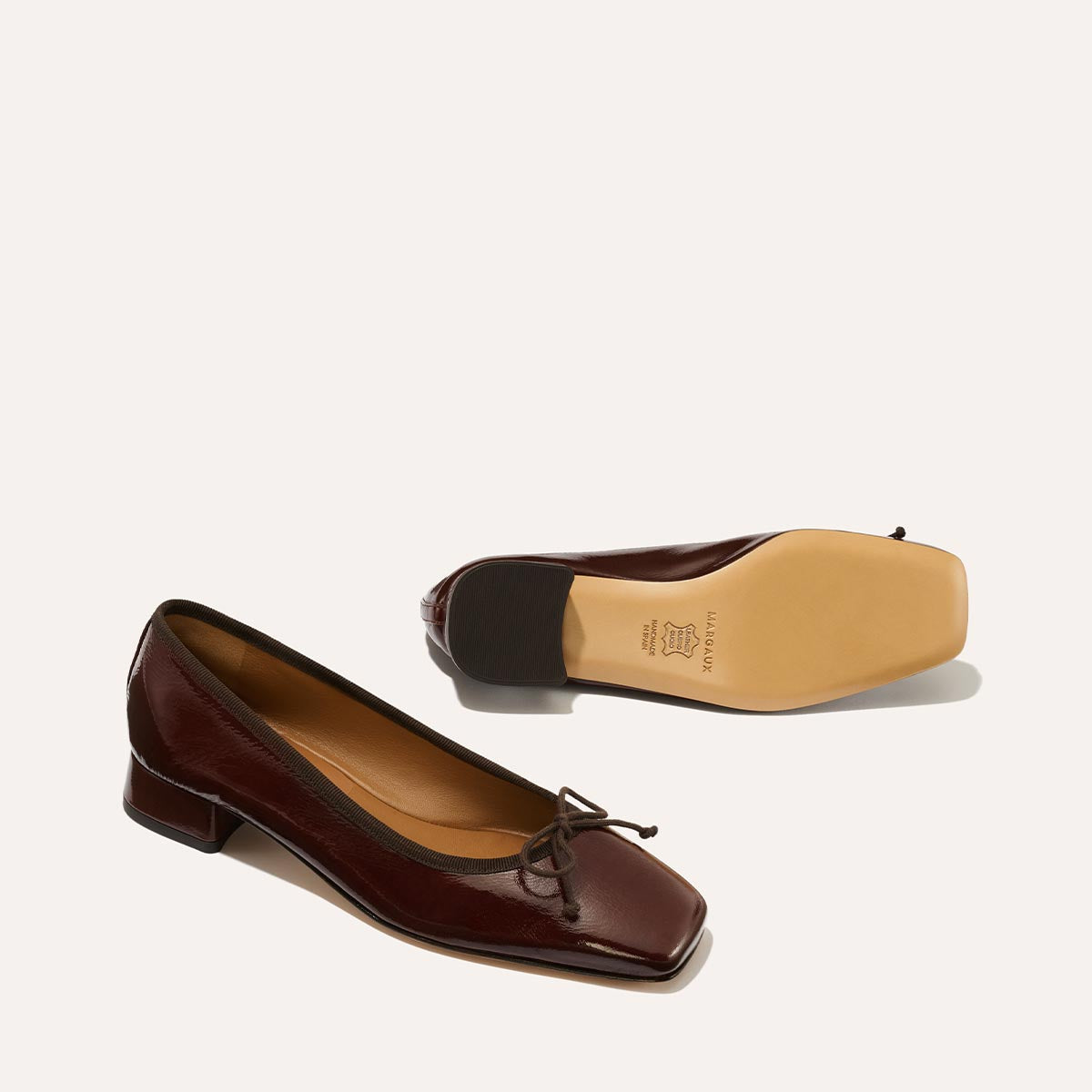 The Ada in Espresso Crinkle Patent, a comfortable ballet flat with a square toe, adjustable cord bow detail, and comfortable 1-inch block heel.