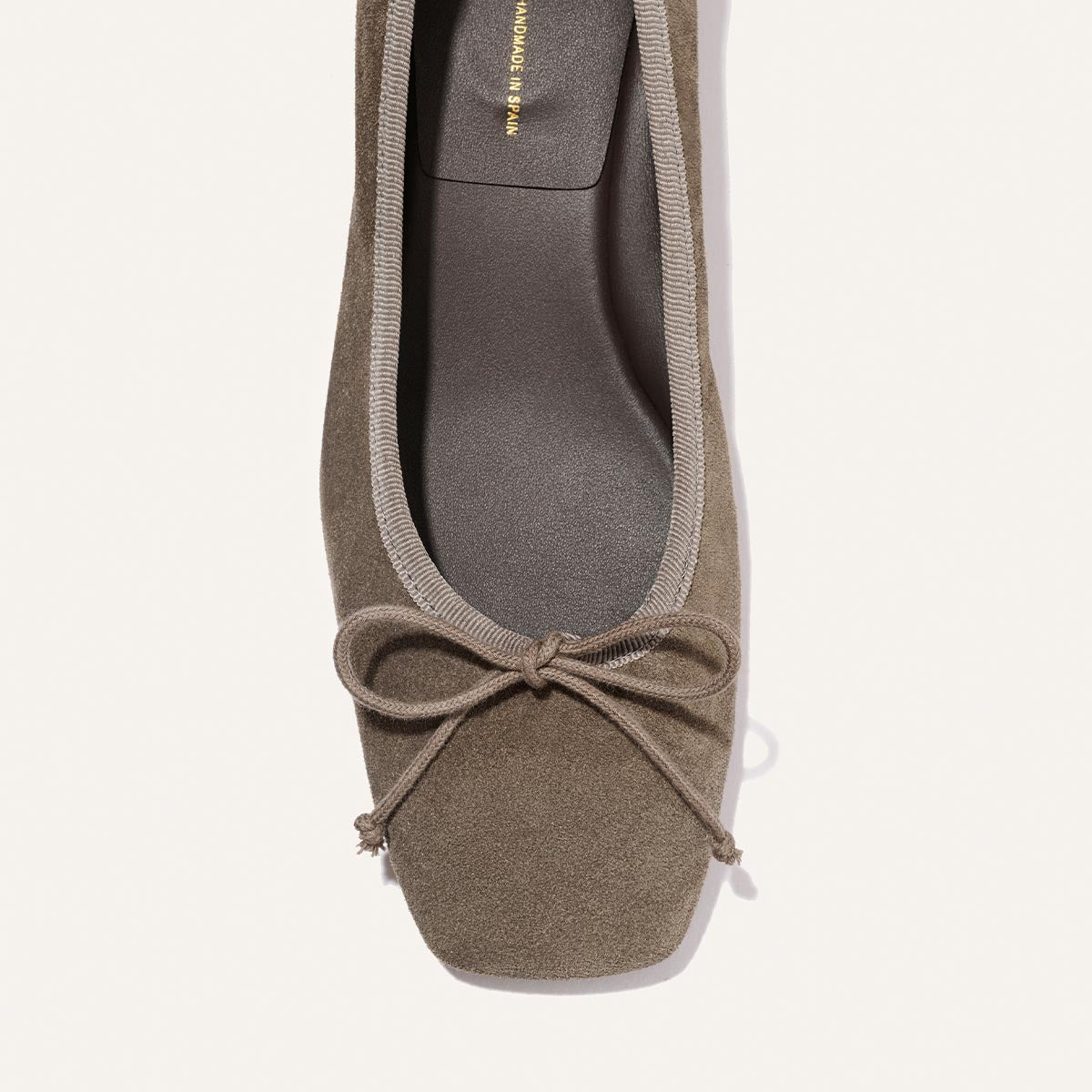 Top view of Margaux's The Ada - Truffle Suede: a taupe suede ballet flat with a square toe, matching trim, and a decorative front bow.