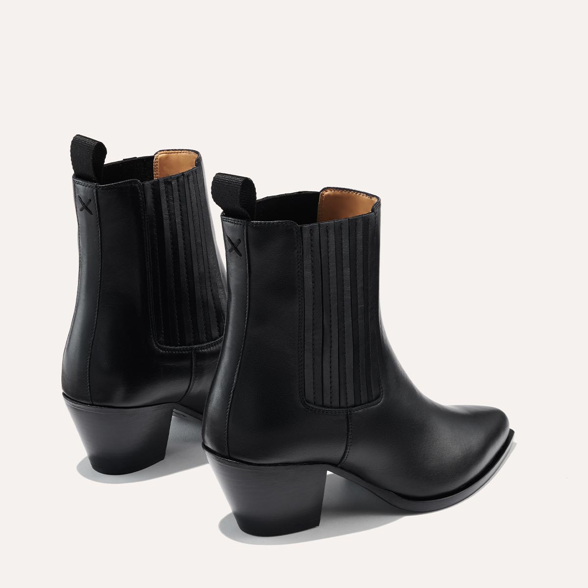 The Agnes Boot in Black Calf, featuring a sleek design inspired by classic Western styles, crafted from high-quality leather with a squared-off toe and angular heel.