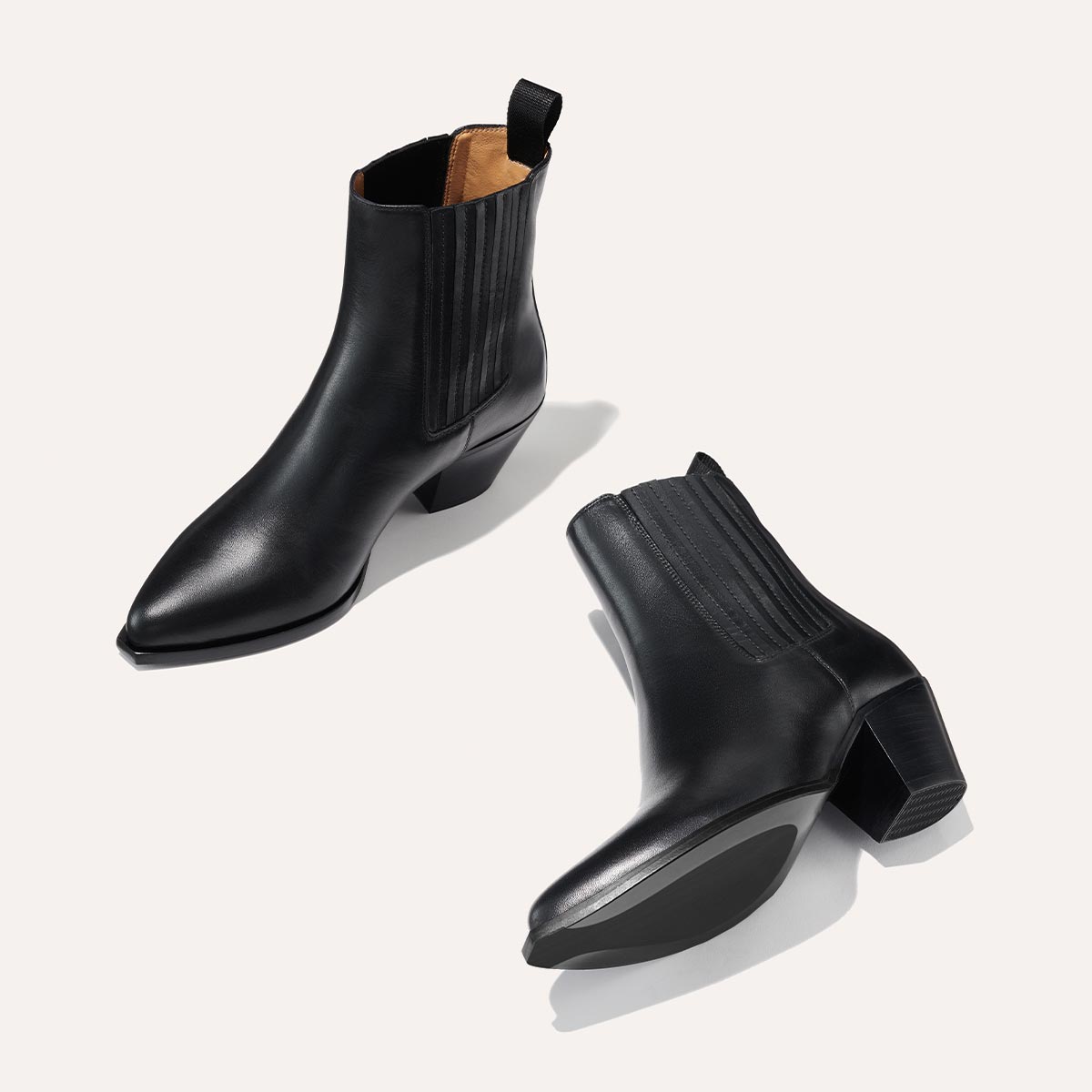 The Agnes Boot in Black Calf, featuring a sleek design inspired by classic Western styles, crafted from high-quality leather with a squared-off toe and angular heel.