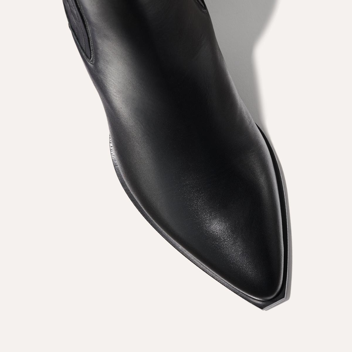 The Agnes Boot in Black Calf, featuring a sleek design inspired by classic Western styles, crafted from high-quality leather with a squared-off toe and angular heel.