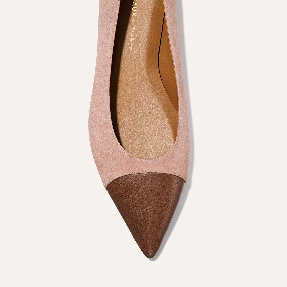 Pink and brown pointed-toe shoe on a light background